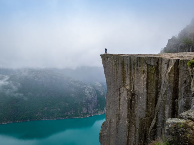 Data Migrations Shouldn't Be Cliffhangers blog post: tourist is standing on the of a cliff