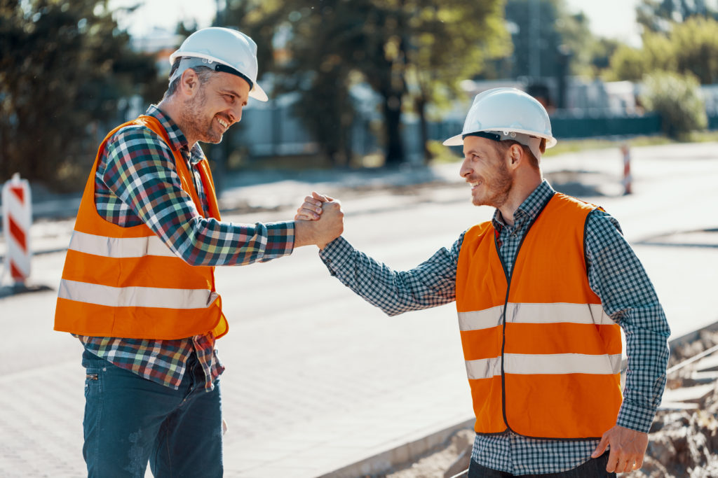 Pavement construction workers celebrating on the job after successful Salesforce implementation within company